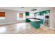 Bright kitchen showcasing green cabinetry, a stainless steel refrigerator, and island with a white countertop at 1801 Griffith Ave, Las Vegas, NV 89104