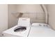 Bright laundry area featuring a side-by-side washer and dryer, and a wire shelf for storage at 1801 Griffith Ave, Las Vegas, NV 89104