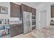 Close-up of a kitchen area with stainless steel appliances, dark wood cabinets, and granite countertops at 2494 Veronella St, Henderson, NV 89044