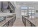 Bright kitchen showcasing granite countertops, dark wood cabinets, stainless steel appliances, and a gas cooktop at 2494 Veronella St, Henderson, NV 89044