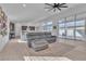Spacious living room with large windows, tile flooring, a modern ceiling fan, and a comfortable sectional sofa at 2494 Veronella St, Henderson, NV 89044