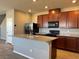 Spacious kitchen featuring dark cabinets, a large island, granite countertops, and modern stainless-steel appliances at 2664 Frabiele St, Henderson, NV 89044