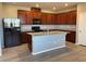 Open concept kitchen with a large island, dark wood cabinets, granite countertops, and stainless-steel appliances at 2664 Frabiele St, Henderson, NV 89044