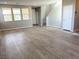 Open-concept living room with wood-look floors, flowing into a well-lit area with multiple windows and a staircase at 2664 Frabiele St, Henderson, NV 89044