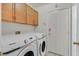 A laundry room with a washer and dryer and wooden cabinets at 681 Peach Coral St, Las Vegas, NV 89183