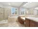 Bathroom with double sink vanity, soaking tub, and separate glass shower enclosure at 7806 Sundial Peak St, Las Vegas, NV 89166