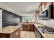 Well-equipped kitchen featuring stainless steel appliances, dark wood plank accent wall and a functional island at 7806 Sundial Peak St, Las Vegas, NV 89166