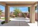 Inviting covered patio overlooking a beautifully landscaped backyard with lush greenery and privacy fencing at 7806 Sundial Peak St, Las Vegas, NV 89166