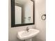 Bathroom features a pedestal sink, framed mirror, and modern fixtures at 7829 Lovely Pine Pl, Las Vegas, NV 89143