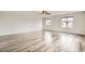 Spacious living room with modern floors, ceiling fan, and natural light from large windows at 7829 Lovely Pine Pl, Las Vegas, NV 89143