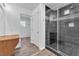 This bathroom features a walk-in shower with black and grey tile, wood-look floors, and modern fixtures at 7865 Solid Horn Ct, Las Vegas, NV 89149