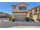 This shot focuses on the garage and front door of a two-story home with desert landscaping at 7865 Solid Horn Ct, Las Vegas, NV 89149