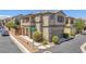 Two-story home with a covered front porch, desert landscaping, and an attached two-car garage at 7865 Solid Horn Ct, Las Vegas, NV 89149