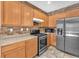 Close up of a kitchen featuring stainless steel appliances, wooden cabinets, and a brick backsplash at 7865 Solid Horn Ct, Las Vegas, NV 89149