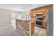 Open kitchen with stainless steel appliances, wooden cabinetry, stone accent wall, and adjacent dining area at 7865 Solid Horn Ct, Las Vegas, NV 89149