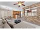 Bright living room featuring a stone wall, comfortable seating, and an open concept design to the kitchen and dining area at 7865 Solid Horn Ct, Las Vegas, NV 89149