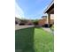 Landscaped backyard featuring artificial grass, planters, and a block wall for privacy at 8902 Sasquatch Run Ave, Las Vegas, NV 89166