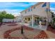 A well-maintained backyard featuring a patio area, a grill, rock ground cover, and mature landscaping at 9021 Canyon Magic Ave, Las Vegas, NV 89129