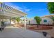 Private backyard featuring a covered patio, manicured landscaping, and a decorative fountain at 9021 Canyon Magic Ave, Las Vegas, NV 89129