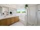 Bright bathroom featuring a double sink vanity, large mirror, soaking tub, and glass-enclosed shower at 9021 Canyon Magic Ave, Las Vegas, NV 89129