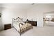 Spacious bedroom with wrought iron bed frame, neutral walls and carpet, and an open doorway at 9021 Canyon Magic Ave, Las Vegas, NV 89129