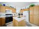 Kitchen featuring wooden cabinets, a center island, and black appliances at 9021 Canyon Magic Ave, Las Vegas, NV 89129