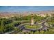 Aerial view of a Primary-planned community showcasing the clock tower in the center of the roundabout at 11640 Desert Hollow Ave, Las Vegas, NV 89138