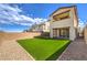 Home backyard with artificial turf, rock landscaping, and a block wall under a bright blue sky at 11640 Desert Hollow Ave, Las Vegas, NV 89138