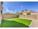 Backyard featuring artificial turf, rock landscaping, and a brick wall against a mountain view at 11640 Desert Hollow Ave, Las Vegas, NV 89138
