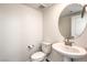Powder room featuring a pedestal sink and oval mirror at 11640 Desert Hollow Ave, Las Vegas, NV 89138