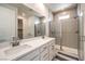 Bathroom featuring double sinks, large mirror and glass-enclosed shower at 11640 Desert Hollow Ave, Las Vegas, NV 89138