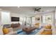 Bright living room with modern furnishings, sleek ceiling fan, and sliding glass doors leading to the backyard at 11640 Desert Hollow Ave, Las Vegas, NV 89138