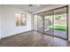 Bright and airy living space with modern flooring, a large window, and sliding glass doors to the private patio at 11640 Desert Hollow Ave, Las Vegas, NV 89138