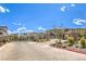 Community entrance street view with gate, landscaping, and neighborhood homes in the background at 11640 Desert Hollow Ave, Las Vegas, NV 89138