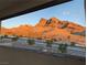 A scenic mountain range view from a window with landscaping below and beautiful light at 11640 Desert Hollow Ave, Las Vegas, NV 89138