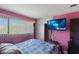 Bedroom featuring pink walls, window view, ceiling fan and television at 1643 E St, Las Vegas, NV 89106