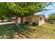 A quaint single-story house with a well-kept lawn and a large tree offering ample shade at 1643 E St, Las Vegas, NV 89106