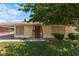 Charming single-story home with stone accents, a well-maintained lawn, and mature tree providing shade at 1643 E St, Las Vegas, NV 89106