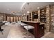 Stylish bar area with stone walls, seating and shelving with wine bottles at 1800 Melfi Ct, Henderson, NV 89012