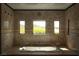 Luxurious bathroom features a soaking tub, marble tiling, and natural light, creating a spa-like retreat at 1800 Melfi Ct, Henderson, NV 89012