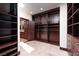 Walk-in closet featuring custom shelving and drawers for optimal storage, plus access to ensuite bathroom at 1800 Melfi Ct, Henderson, NV 89012