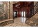Elegant foyer featuring a stone mosaic wall and grand staircase with decorative iron railings at 1800 Melfi Ct, Henderson, NV 89012