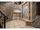 A grand stone foyer features a curved staircase, mosaic art, and an arched entryway at 1800 Melfi Ct, Henderson, NV 89012