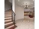 Grand foyer with curved staircase and tiled floors leading to a living space at 1800 Melfi Ct, Henderson, NV 89012