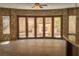 Stone-clad room features a tile floor and folding glass doors to an outdoor fireplace and entertainment area at 1800 Melfi Ct, Henderson, NV 89012