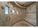 Luxurious tiled shower with multiple shower heads and custom seating at 1800 Melfi Ct, Henderson, NV 89012