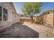 A large yard features mature trees, a partial privacy wall, and a home with stone facade at 1800 Melfi Ct, Henderson, NV 89012