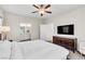 Bright main bedroom with ceiling fan, bathroom access and neutral décor, and a TV at 4333 Glossier Ave, North Las Vegas, NV 89084