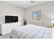 Cozy bedroom featuring neutral paint, carpet, a large TV, and a window providing natural light at 4333 Glossier Ave, North Las Vegas, NV 89084