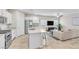 Modern kitchen island view opens to living area with stainless steel appliances and white cabinetry at 4333 Glossier Ave, North Las Vegas, NV 89084